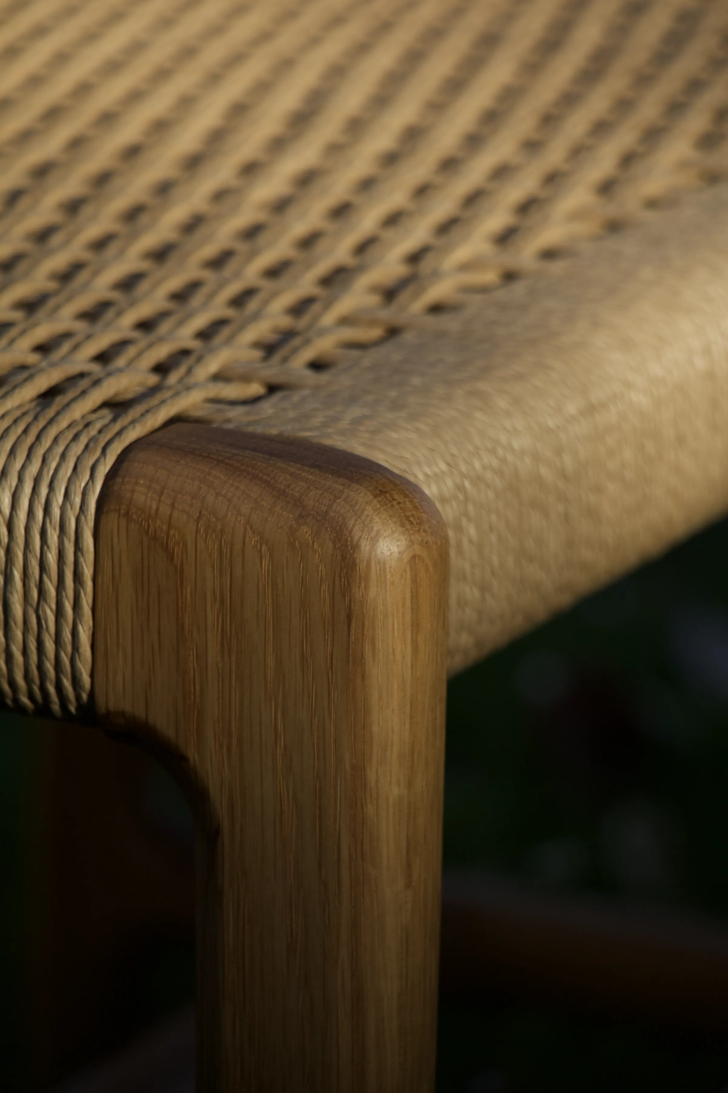 Detalle de la esquina de un banco de roble con asiento de cordón