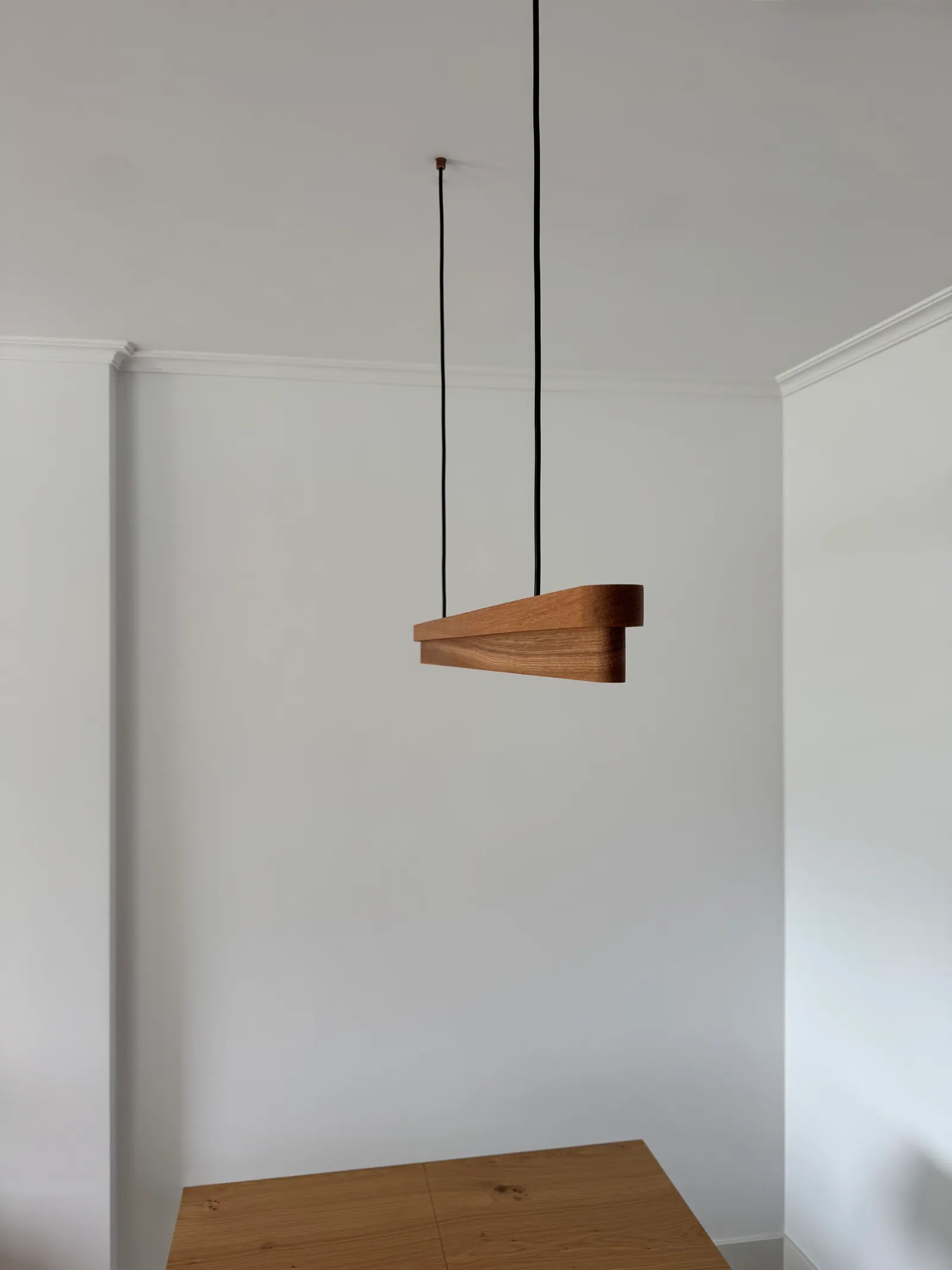 Lámpara colgante de roble en una habitación blanca