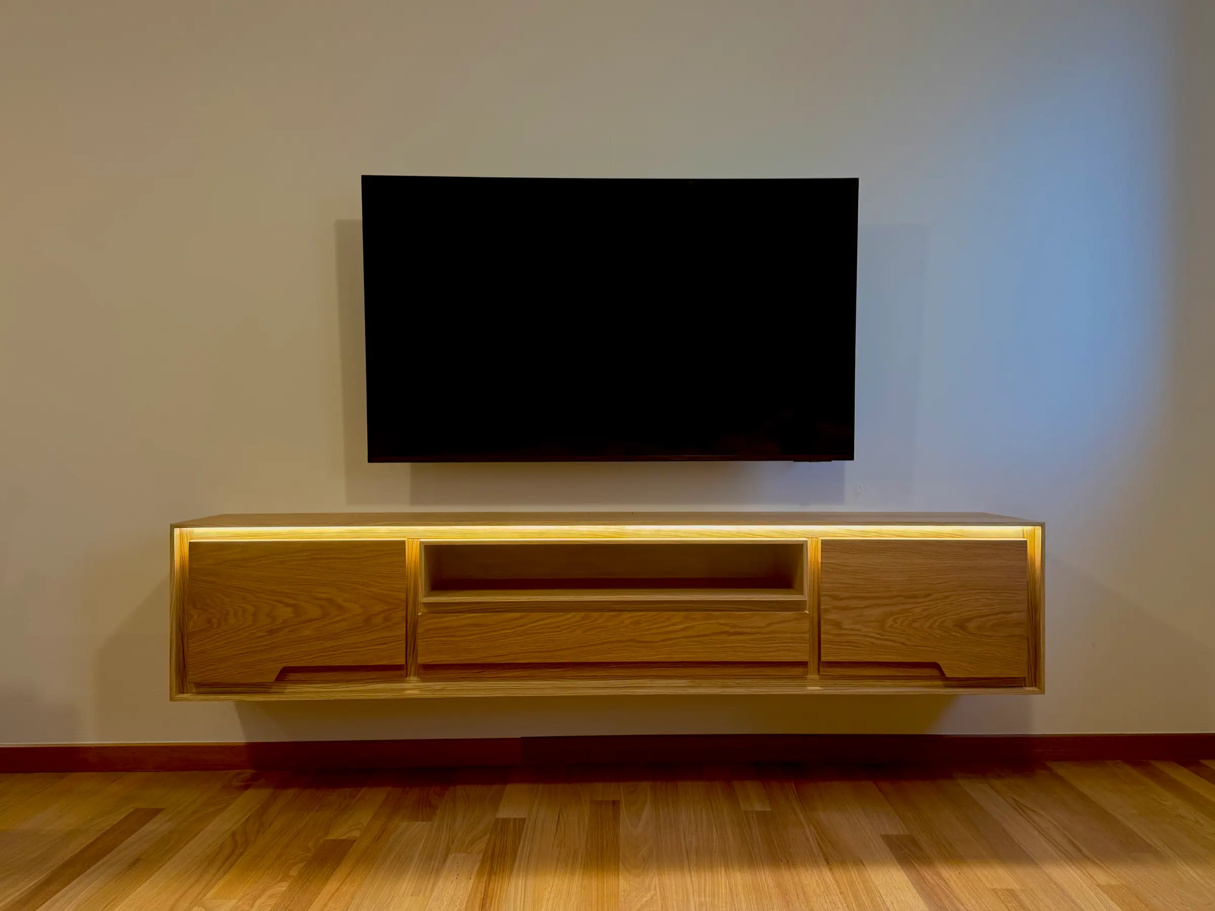 Mueble de televisión de roble suspendido, con la luz integrada encendida